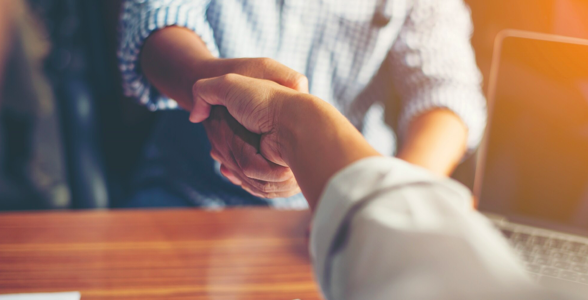 Imagen en la que aparecen dos personas dándose la mano, como cerrando un contrato laboral.